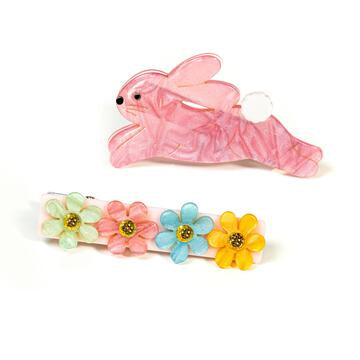 A pair of hair alligator clips with one clip designed as a pink bunny and the other with a series of colorful flowers.