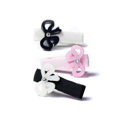 Set of three metal based hair clips each adorned with a bow. One has black bow, the second has a pink bow and the third one has a white bow
