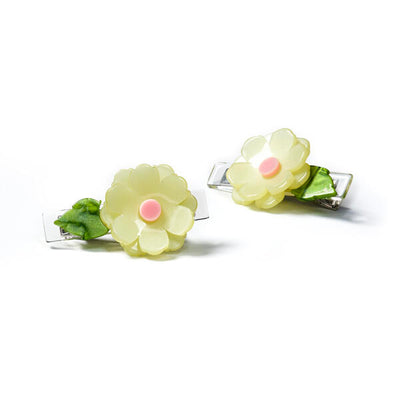 Pair of metal based hair clips each adorned with a light yellow and pink acrylic peony like flower and a green leaf.