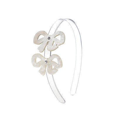 Clear acrylic headband adorned with two white pearlized bows