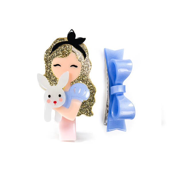 Pair of hair clips. One is adorned with a blue statement bow. The second one is adorned with a blonde doll holding a cute bunny.