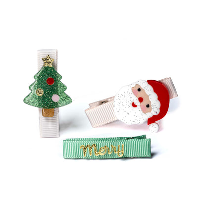 Set of Christmas-themed hair clips including a tree, Santa Claus, and 'Merry' ribbon on a white background.