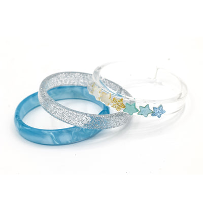 Acrylic set of three bracelets. One is silver glitter, one is pearly blue and one is clear adorned with seven glitter stars in different colors.