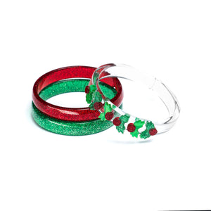 Acrylic set of three bracelets. One is red glitter, one is green glitter and one is clear adorned with six mistletoe in red and green glitter. 