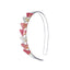 Clear acrylic headband adorned with seven small Christmas trees in different shades of pink.
