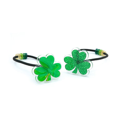 Pair of hair ties adorned with glittery green shamrocks.